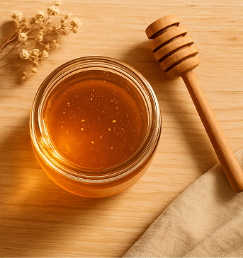 A jar of raw organic honey with a wooden honey dipper